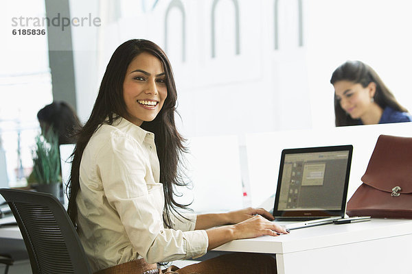Geschäftsfrau  Notebook  lächeln  Büro  tippen