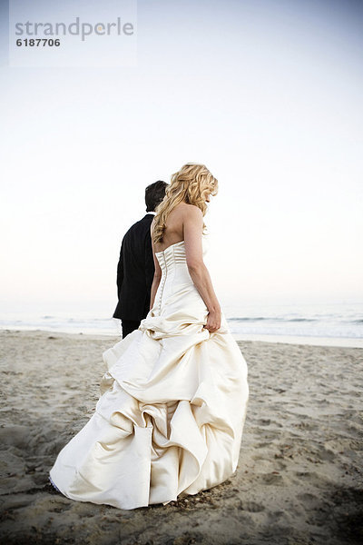 Braut und Bräutigam Wandern am Strand