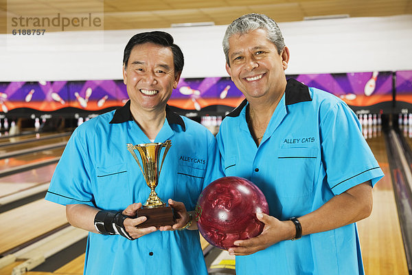 Teamwork  halten  multikulturell  Ball Spielzeug  Bowling  Pokal