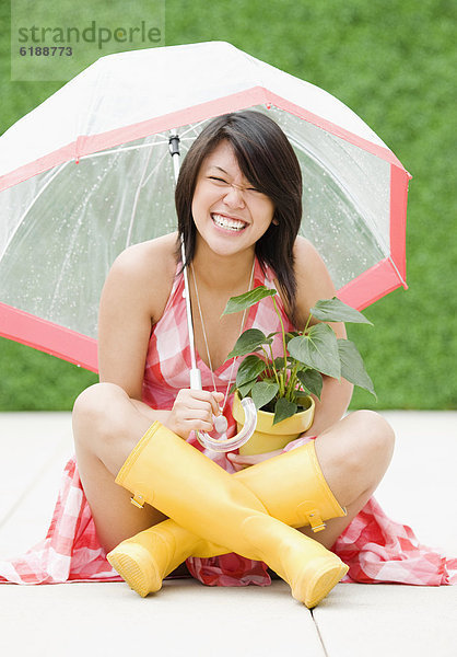 sitzend  Frau  Regenschirm  Schirm  Regen  unterhalb