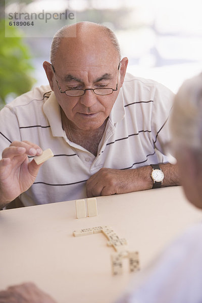 Außenaufnahme  Senior  Senioren  Mann  Dominostein  freie Natur  spielen