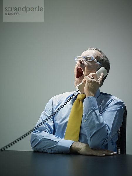 Europäer  sprechen  Geschäftsmann  Telefon  gähnen