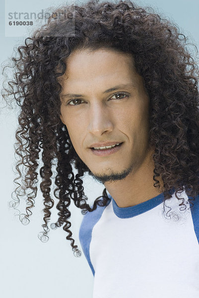 Hispanic man with long  curly hair