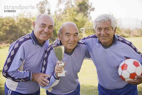 Senior Senioren halten Spiel Fußball Ball Spielzeug Chillipulver Chilli Pokal