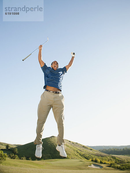 In der Luft schwebend  Begeisterung  schwarz  springen  Golfspieler  Golfsport  Golf  Kurs