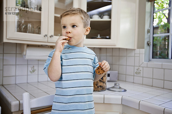 Europäer  Junge - Person  Küche  essen  essend  isst  Keks