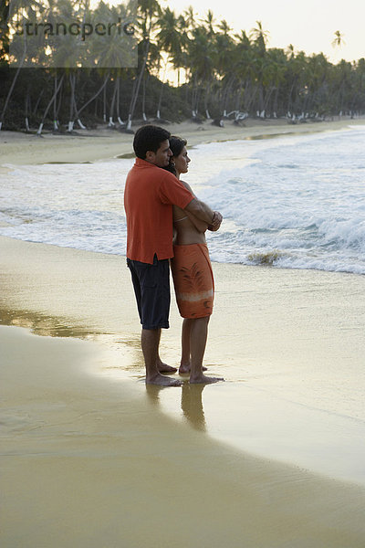 Paar umarmt sich am Meer