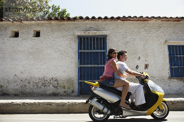 Couple riding scooter