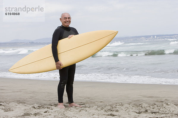 Senior Senioren Mann Strand Hispanier halten Surfboard