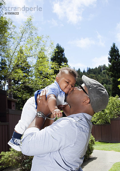 Menschlicher Vater  Sohn  heben  küssen  amerikanisch  Baby