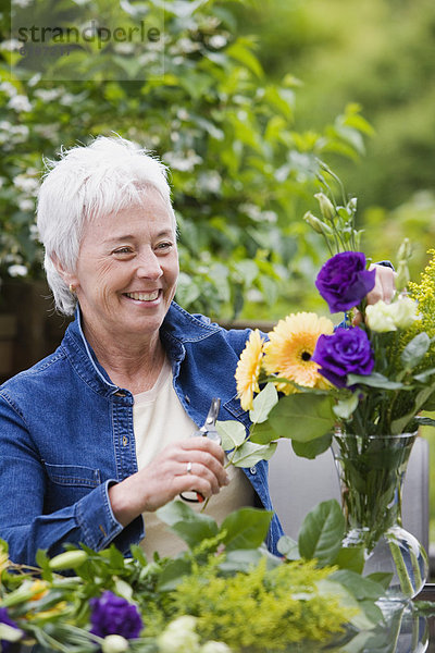 Senior  Senioren  Frau  Blume  lächeln  arrangieren  Blumenvase