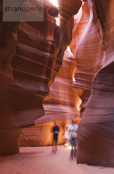 Tourists visiting unusual  orange rock formations in cave