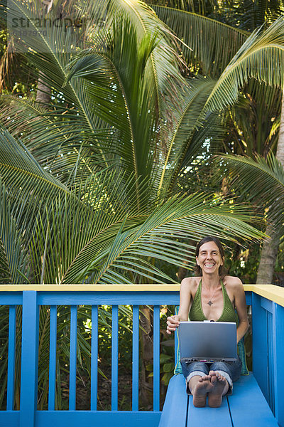 benutzen Frau Notebook Hispanier lächeln Terrasse