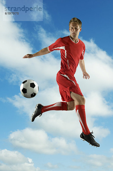 Fußballspieler In der Luft schwebend treten springen Ball Spielzeug