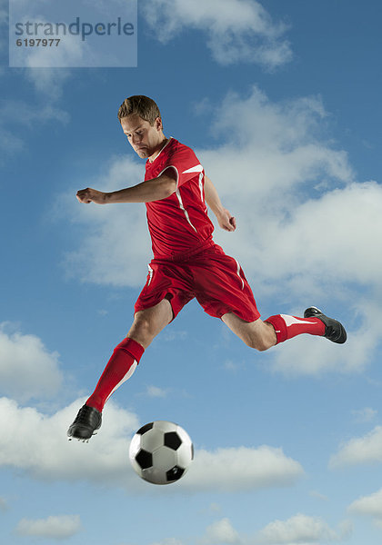 Fußballspieler In der Luft schwebend treten springen Ball Spielzeug