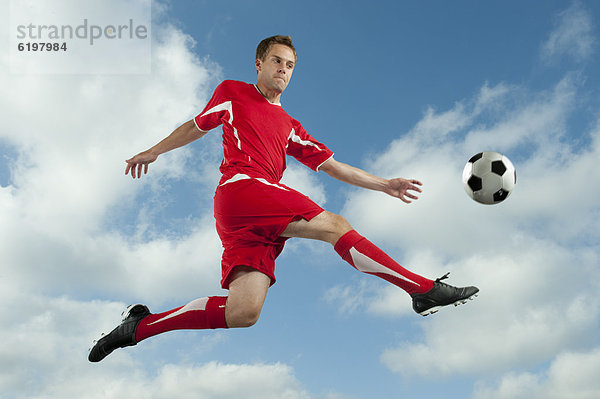 Fußballspieler In der Luft schwebend treten springen Ball Spielzeug