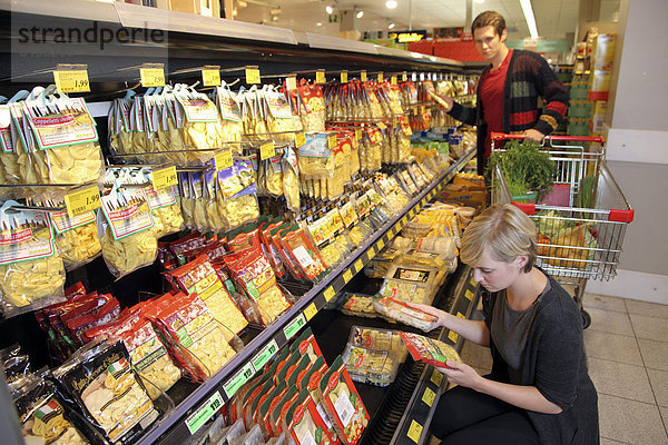 Kunden an Kühltheke mit frischen Nudeln  Pastaprodukte  Lebensmittelabteilung  Supermarkt  Deutschland  Europa