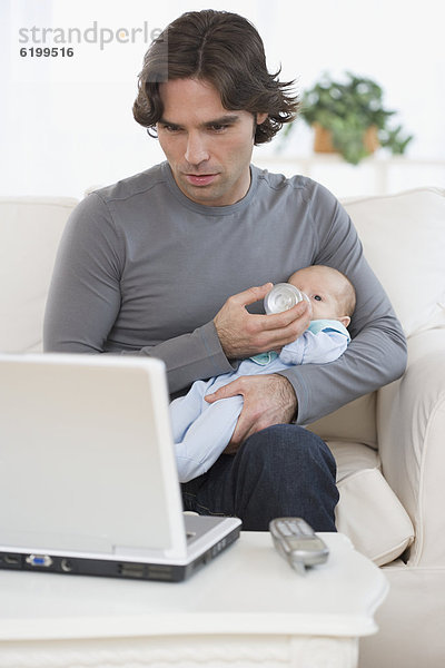 sehen  Notebook  Menschlicher Vater  Hispanier  Baby  füttern