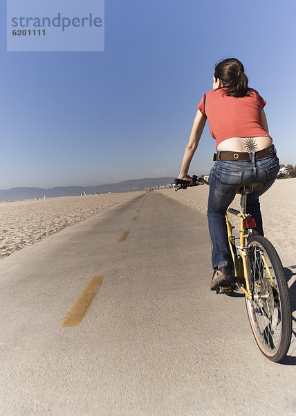 Frau Fahrradfahren am Strand