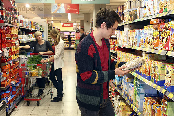 Mann kauft Mueslimischung ein  Lebensmittelabteilung  Supermarkt  Deutschland  Europa