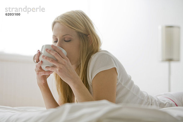 liegend  liegen  liegt  liegendes  liegender  liegende  daliegen  Europäer  Frau  Bett  trinken  Kaffee