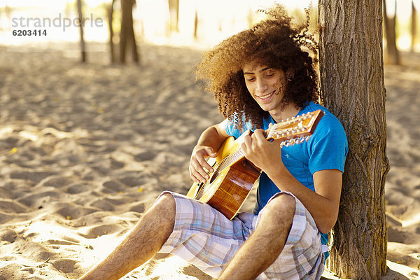 sitzend  Jugendlicher  Sand  mischen  Gitarre  musizieren  Musik machen  Mixed