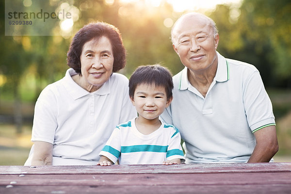 Außenaufnahme  sitzend  chinesisch  Großeltern  Enkelsohn  freie Natur