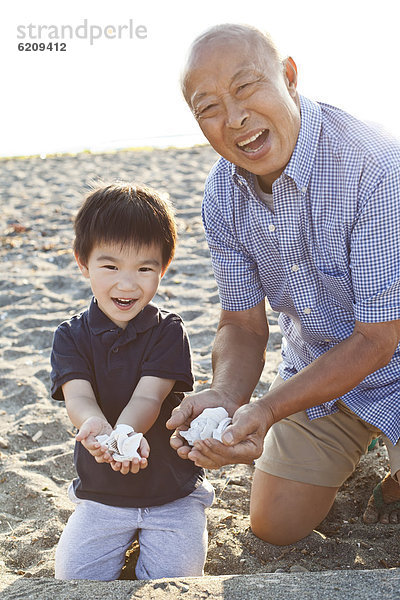 Strand geselliges Beisammensein chinesisch Enkelsohn Großvater
