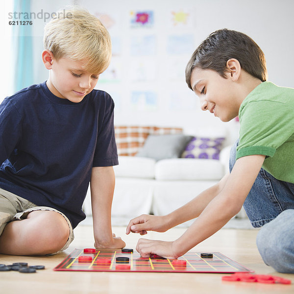 Damespiel  Dame  sitzend  Boden  Fußboden  Fußböden  Junge - Person  spielen