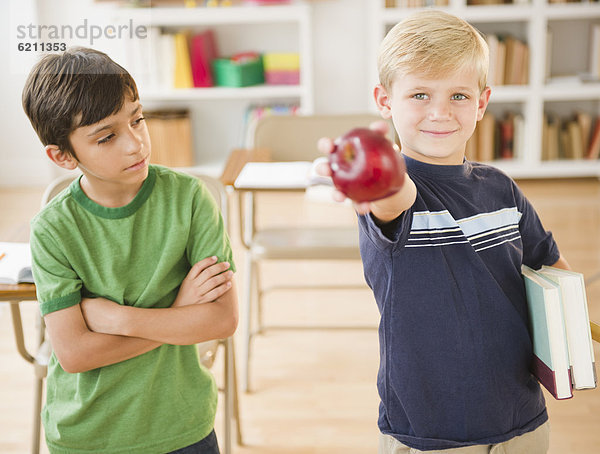 Junge - Person  Klassenzimmer  Apfel  halten