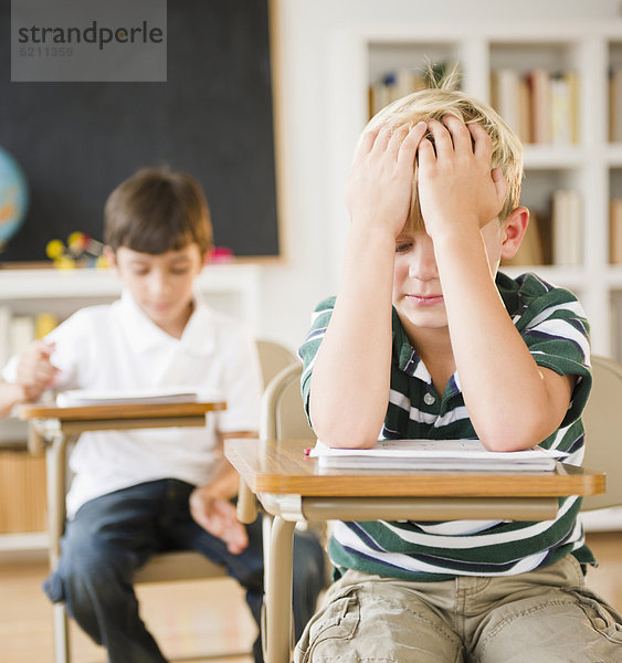 sitzend  Europäer  Schreibtisch  Enttäuschung  Junge - Person  Klassenzimmer