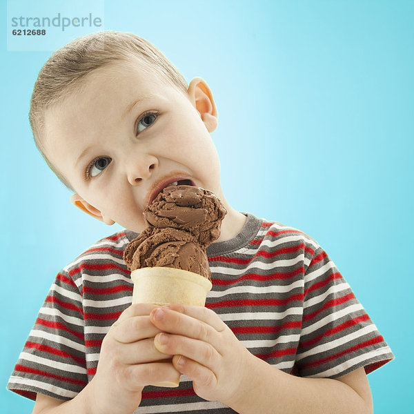 kegelförmig  Kegel  Europäer  Junge - Person  Eis  essen  essend  isst  Sahne