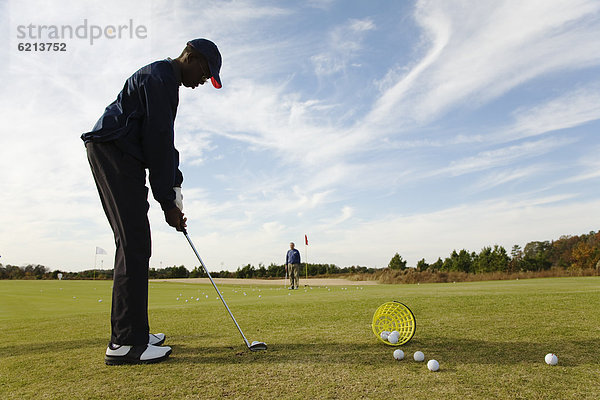 Junge - Person  üben  einlochen  Golfsport  Golf  Kurs