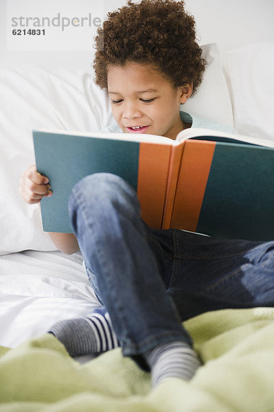 Buch  Junge - Person  Bett  schwarz  Taschenbuch  vorlesen