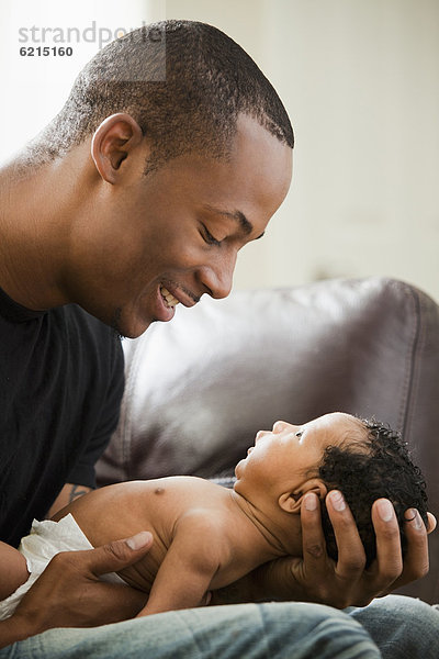 Vater hält neugeborenes Baby