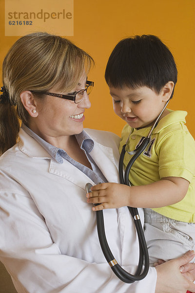 Junge - Person  Arzt  Hispanier  halten  Baby