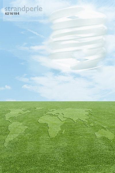 Continents in green grass  CFL light bulb in sky