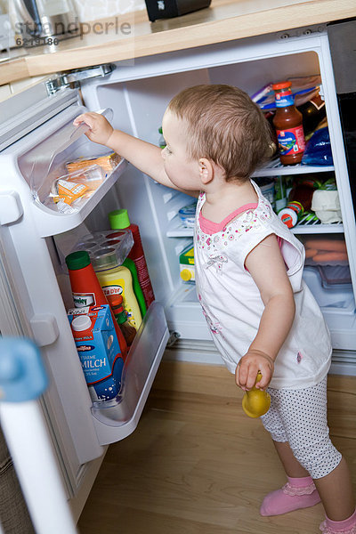 Kleines Mädchen am Kühlschrank