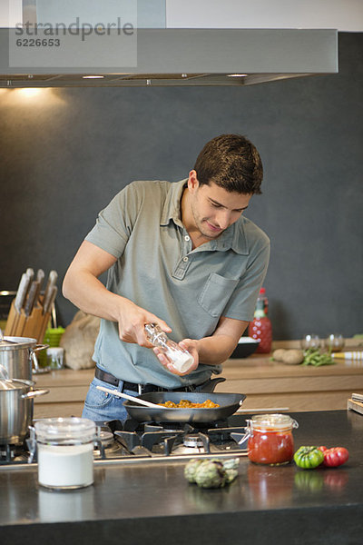 Mann bei der Zubereitung von Speisen in der Küche