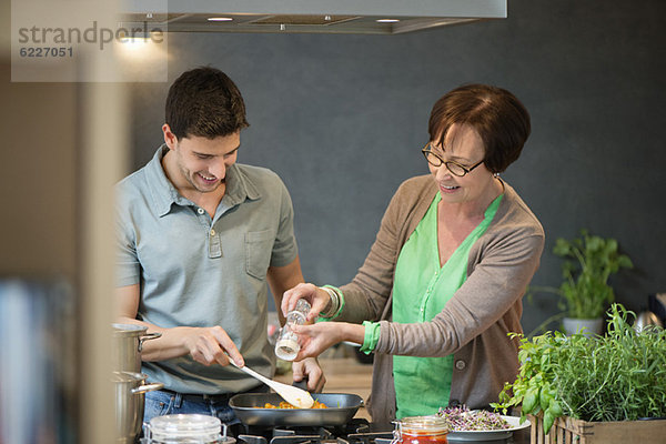 Frau  die ihrem Sohn beim Kochen hilft