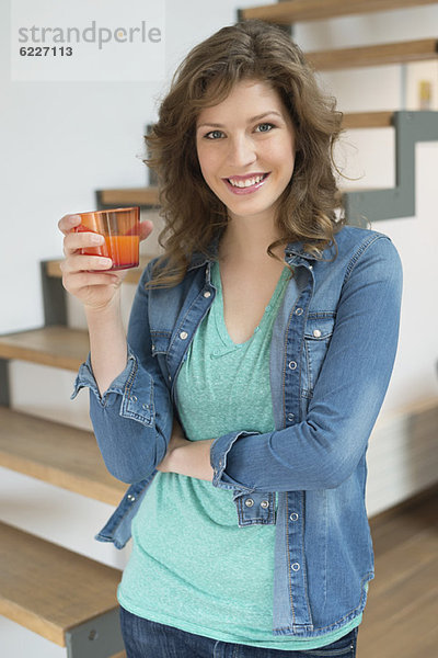Porträt einer glücklichen Frau mit einem Glas Getränk