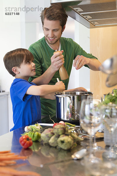 Junge assistiert seinem Vater in der Küche