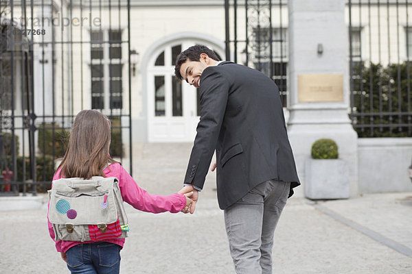 Mädchen mit ihrem Vater auf dem Weg zur Schule
