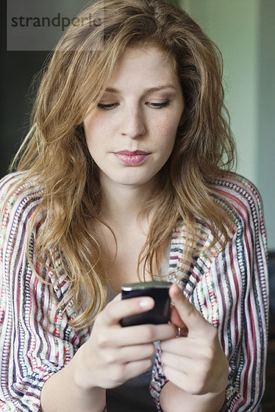 Nahaufnahme einer schönen Frau SMS auf einem Handy