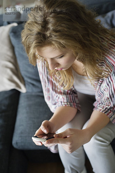 Textnachrichten von Frauen auf dem Handy zu Hause