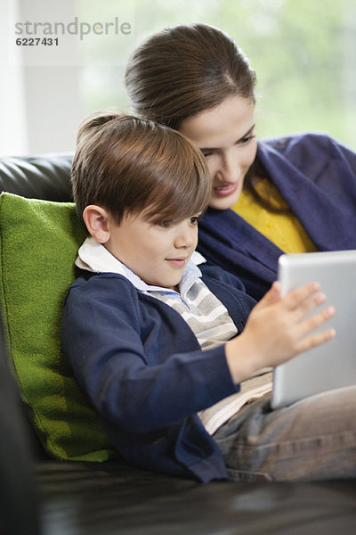 Frau und ihr Sohn betrachten ein digitales Tablett