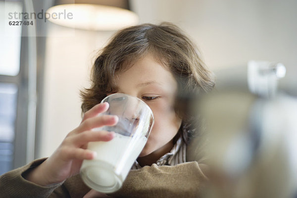Nahaufnahme eines Jungen  der ein Glas Milch trinkt.