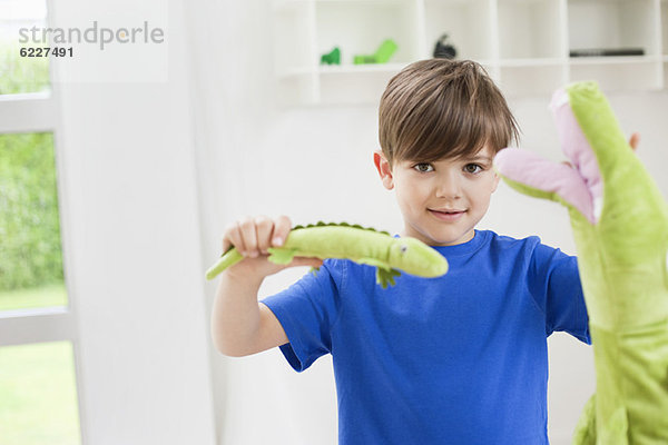 Porträt eines Jungen  der mit Tierspielzeug spielt