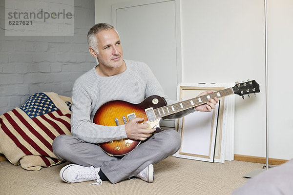 Mann  der zu Hause Gitarre spielt