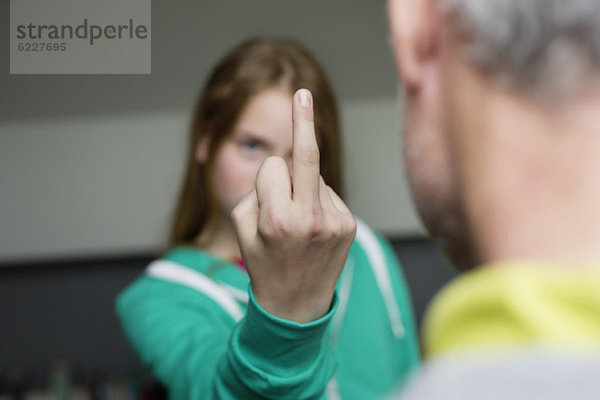 Mädchen zeigt ihrem Vater den Mittelfinger